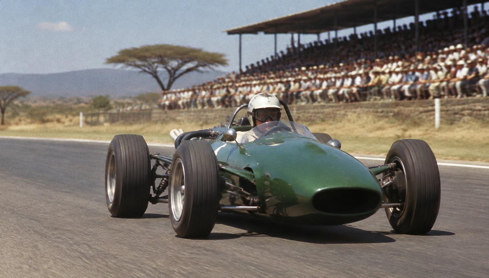 Illustrative archive-style image of a 1960s racing car on an African circuit in front of a crowded grandstand